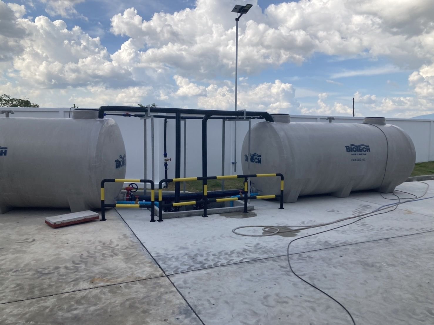 Two water storage tanks connected by black pipework